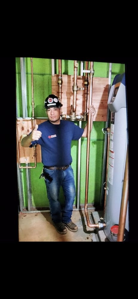 Copan Plumbing technician installing copper piping and a water heater