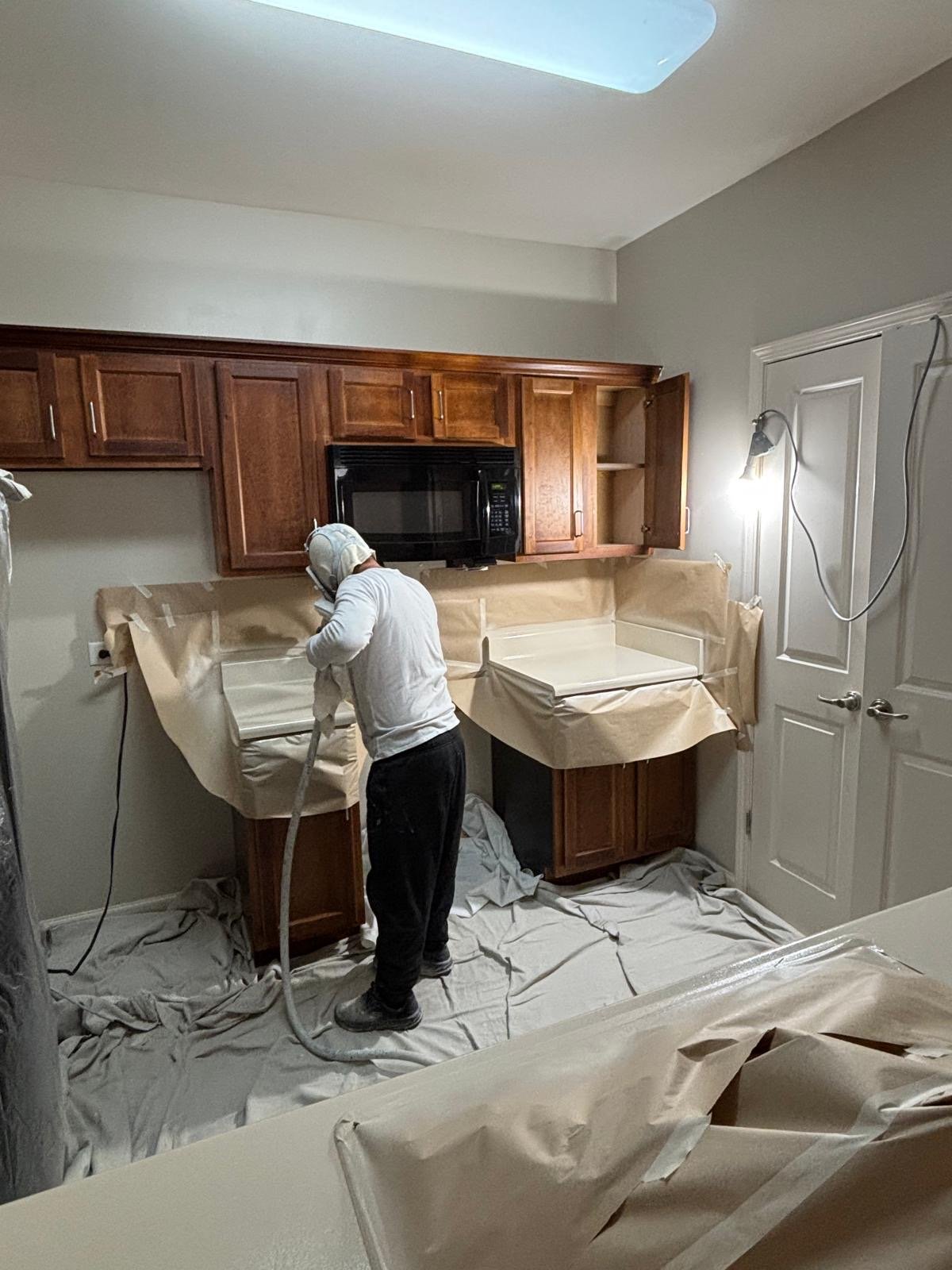 Technician refinishing a bathtub and countertop